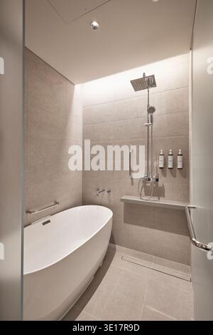 Minimales Badezimmer mit Wanne, Dusche und Betonwänden. Stockfoto