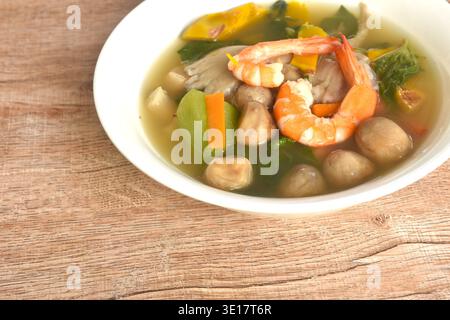 Gekochtes, scharfes gemischtes Gemüse mit frischen Garnelen, in der Suppe in Herzform auf einer Schüssel angeordnet wird Stockfoto