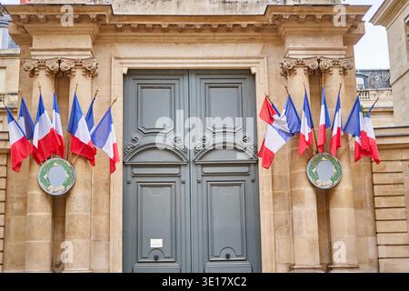 Das Bild zeigt den großen neoklassizistischen Eingang eines offiziellen Regierungsgebäudes in Paris, Frankreich. Die symmetrische Fassade verfügt über... Stockfoto