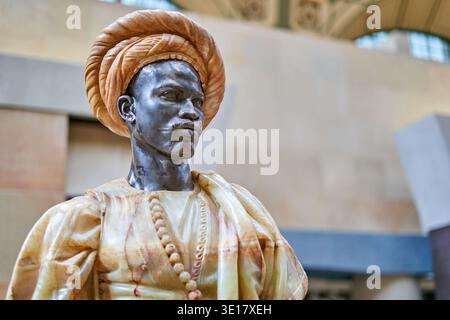 Eine detaillierte Nahaufnahme einer polychromen Skulptur, die eine männliche Figur in traditioneller Kleidung aus Nordafrika oder dem Nahen Osten darstellt Stockfoto