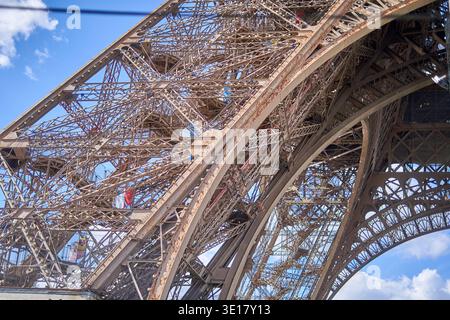 Eine Nahaufnahme aus dem niedrigen Winkel, die die komplizierte Eisengitterstruktur des Eiffelturms in Paris, Frankreich, erfasst. Das Foto zeigt die... Stockfoto
