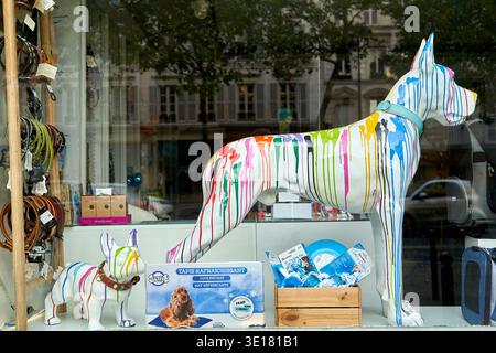 Künstlerische Hundepuppen im Pariser Tierhandelfenster mit farbenfrohen Regenbogenfarben auf weißen Skulpturen Stockfoto