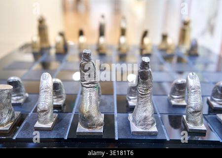 Künstlerisches Schachset mit Fingern- und Daumenfiguren auf schwarzem Hochglanzbrett Stockfoto