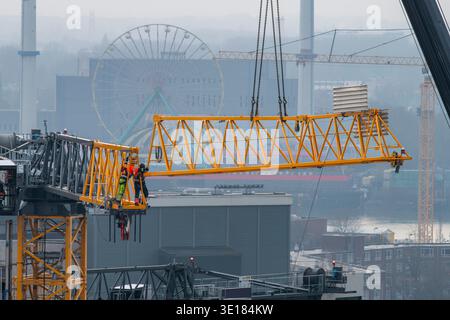 Nahaufnahme der Oberseite eines Turmdrehkrans auf einer Baustelle, bei der ein Ausleger oder horizontale Träger angehoben werden, um mit dem verbunden zu werden Stockfoto