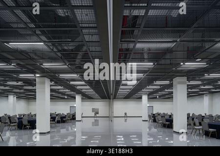 Großraumbüros im Industriestil mit freiliegender Decke und mehreren Schreibtischen. Stockfoto