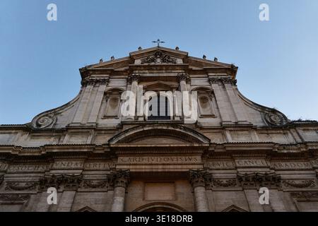 Historische Kirchenfassade bei Dämmerung mit warmen Steintönen. Stockfoto