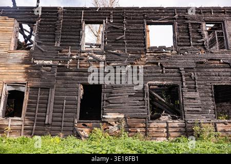Verbrannte Holzfassade mit erheblichen Brandschäden und Zerstörung Stockfoto