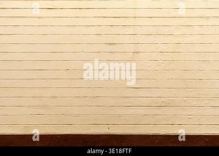 Alte gelbe Ziegelmauer mit viel Textur und Farbe. Abstraktes Muster einer alten roten, orangen und schwarzen Ziegelwand mit viel Textur, die für den Rücken nützlich ist Stockfoto