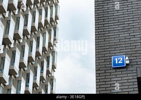 Moderne Architektur steht im Kontrast zur Backsteinmauer und Straße Nr. 12, urbanen Details Stockfoto