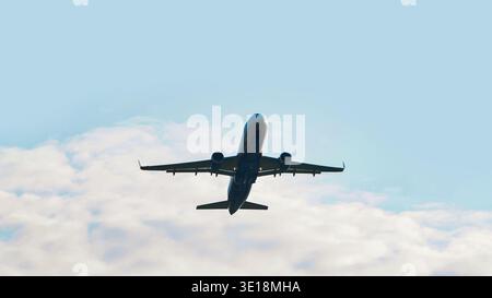 Ein Flugzeug fliegt gegen einen blauen Himmel. Nahaufnahme des Flugzeugs. Stockfoto