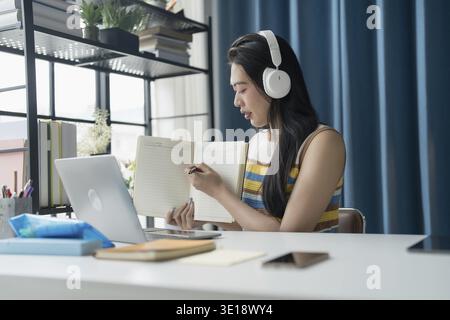 Junger asiatischer Tutor mit Headset lächelnd Videoanruf Erklärungsstunde Online-Tutoring von zu Hause aus Stockfoto
