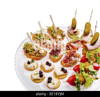 Eine verlockende Auswahl an Gourmet-Vorspeisen präsentiert eine Vielzahl von Aromen auf einem dekorativen Tablett. Jede mundgroße Leckerei ist kunstvoll mit frischem i arrangiert Stockfoto
