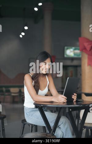 Junge schöne Frau, die einen digitalen Tablet-Computer benutzt Stockfoto