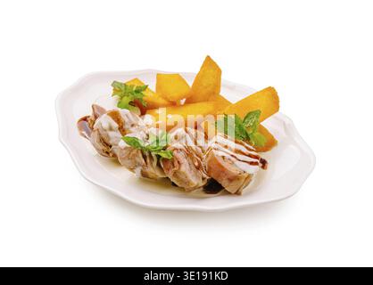 Gegrillte Hähnchenspieße werden kunstvoll auf einem weißen Teller zusammen mit lebhaften Mangoblättern angeordnet. Frische Kräuter verleihen diesem Appeti einen Hauch von Farbe Stockfoto