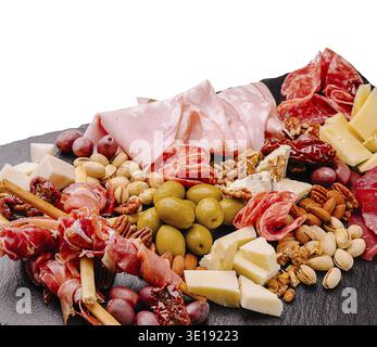 Auf der schön angeordneten Wurstplatte finden Sie verschiedene Wurstsorten, Käse, Oliven und Nüsse, ideal für Treffen oder zwanglose Speisen. Perfekt für Stockfoto