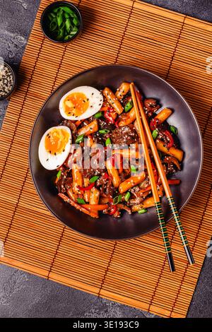 Tteokbokki, scharfer, gebratener Reiskuchen mit Rindfleisch und Gemüse. Stockfoto