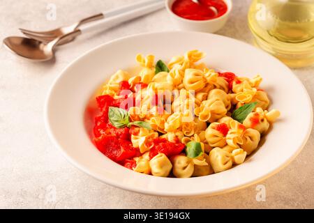 Italienische Pasta mit Füllung. Sacсhettini Nudeln auf einem Teller mit Tomatensauce. Stockfoto