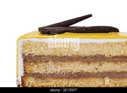 Köstliches Stück Kuchen mit Schichten Biskuitkuchen und Schokoladencreme, gekrönt mit gelber Glasur und Schokoladendekoration Stockfoto