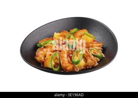 Süß-saure Garnelen mit Reis, Ananas und Chili auf schwarzem Teller Stockfoto