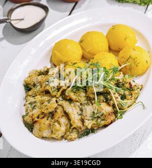 Nahrhafte Mahlzeit mit gegrilltem Huhn, gekochten Kartoffeln und frischem Gemüse auf einem weißen Teller Stockfoto