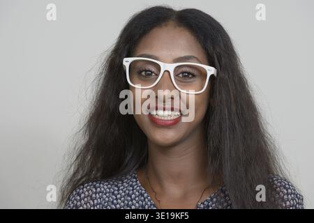 Studioaufnahme der jungen schönen afrikanischen Frau vor weißem Hintergrund Stockfoto