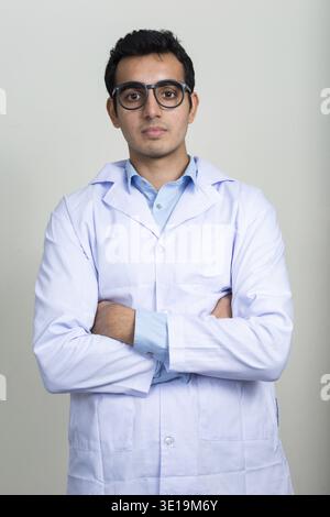 Studio shot der jungen schönen Indischen mann Arzt vor weißem Hintergrund Stockfoto