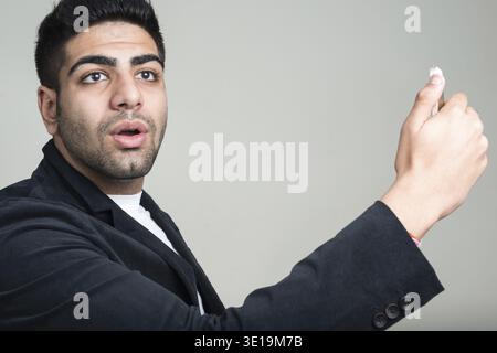 Studio-Aufnahme eines jungen gutaussehenden, bärtigen indischen Geschäftsmannes vor weißem Hintergrund Stockfoto