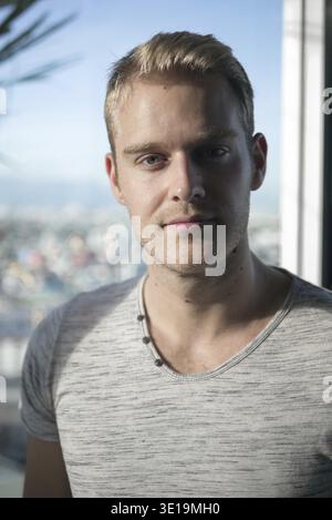 Porträt von jungen schönen Mann mit blonden Haaren in der Stadt im Freien Stockfoto