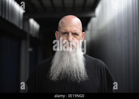 Porträt eines reifen, gutaussehenden, kahlbärtigen Mannes in den Straßen der Stadt im Freien Stockfoto