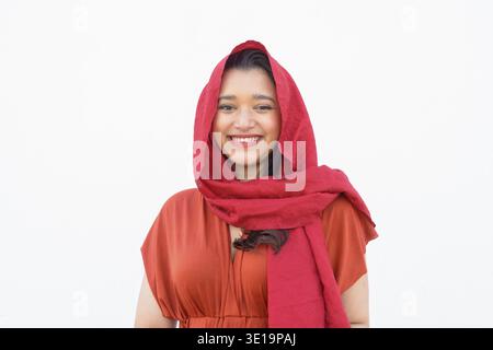 Porträt einer jungen, schönen Indianerin, die im Freien ein Kopftuch vor der weißen Wand trägt Stockfoto