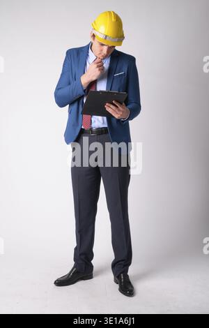 Studio shot der Geschäftsmann als Ingenieur tragen, hardhat vor weißem Hintergrund Stockfoto