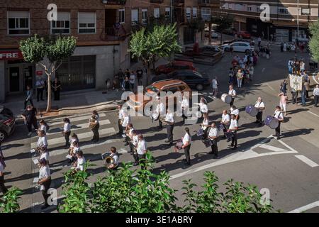 Während der Fiesta del Pilar in Vila-Real, Spanien, tritt eine Marschkapelle auf, während die Zuschauer von den Bürgersteigen aus zusehen. Stockfoto