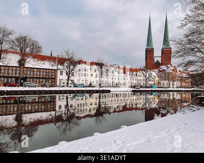 Trave Flussufer mit schneebedeckten Böschungen und Kirchtürmen der St. Marys in Lübeck Stockfoto