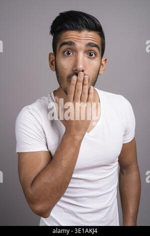 Studio shot der jungen schönen persischen Mann gegen grauer Hintergrund Stockfoto