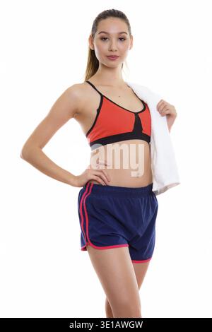Studio erschossen Der junge schöne asiatische Frau mit Handtuch über der Schulter bereit für Fitnessraum Stockfoto
