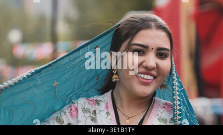 Moskau, Russland - 17. August 2025: Junge Indianerin lächelt und hält ihre blaue Dupatta Stockfoto