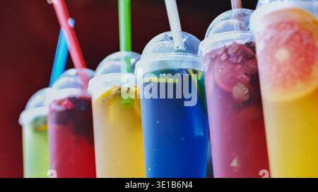 Reihe verschiedener gekühlter Obstgetränke mit Strohhalmen, perfekt für ein Sommerfest oder eine Veranstaltung Stockfoto