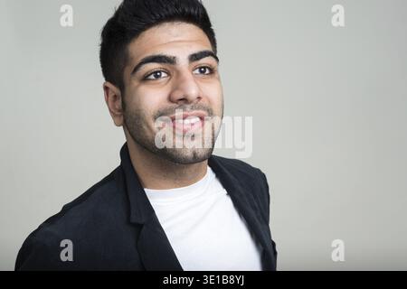 Studio-Aufnahme eines jungen gutaussehenden, bärtigen indischen Geschäftsmannes vor weißem Hintergrund Stockfoto