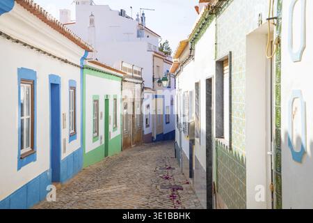 Ferragudo, Algarve, Portugal.26. september 2020. Traditionelle weiße Häuser mit Ziegeldächern in engen Gassen, dekoriert mit Bougainvillea-Blumen im Th Stockfoto