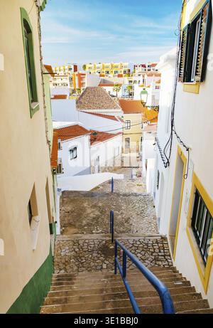 Ferragudo, Algarve, Portugal.26. september 2020. Traditionelle weiße Häuser mit Ziegeldächern in engen Gassen, dekoriert mit Bougainvillea-Blumen im Th Stockfoto