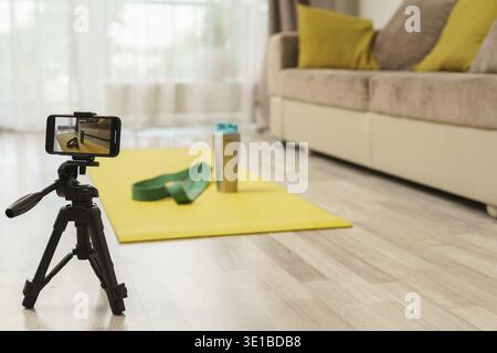 Smartphone auf einem Stativ, das Videos mit einem Gerät für das Heimtraining aufnimmt. Konzepte des Online-Fitnesstrainings oder Vlogging Stockfoto