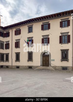 Biblioteca Del Dipartimento Di Diritto Pubblico. Pisa, Italien. Neoklassizistische Architekturdetails, leere piazza, italienische und EU-Flaggen fliegen. Stockfoto