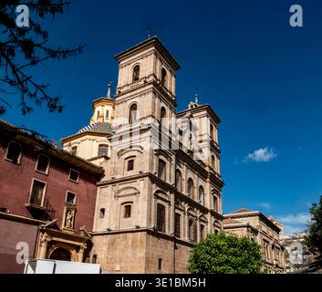 Die Fassade der Kirche Santo Domingo in Murcia, Spanien, mit gemauerten Glockentürmen und einer gelb gekachelten Kuppel vor einem tiefblauen Himmel. Stockfoto