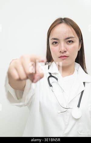 Porträt einer jungen asiatischen Ärztin vor weißem Hintergrund mit Labormantel und Stethoskop Stockfoto