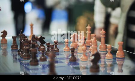 Schachfiguren auf Glasplatte mit strategischer Herausforderung und Wettbewerbskonzept Stockfoto