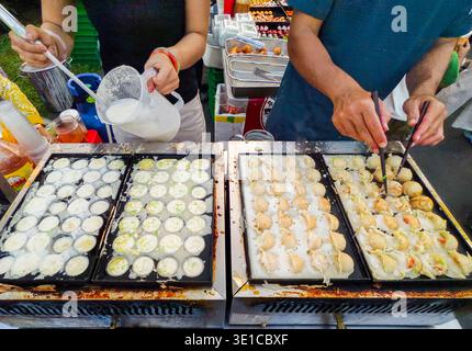 Street Food Stand mit Köchen, die Takoyaki, herzhafte, kugelförmige Pfannkuchen und gewürfelte Oktopus zubereiten. Phnom Penh, Kambodscha Stockfoto