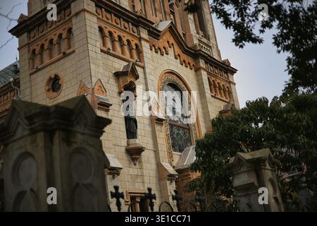 Eine professionelle Tiefwinkelaufnahme einer majestätischen Kathedrale im gotischen Stil. Die Fassade besteht aus kompliziertem Steinmauerwerk, spitzen Türmen mit Kreuzen, A Stockfoto
