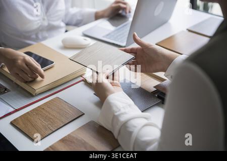 Innenarchitektin präsentiert umweltfreundliche Holzmaterialmuster für nachhaltige Wohnkultur Stockfoto