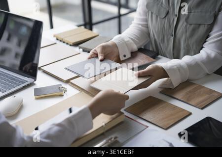 Innenarchitektin präsentiert umweltfreundliche Holzmaterialmuster für nachhaltige Wohnkultur Stockfoto