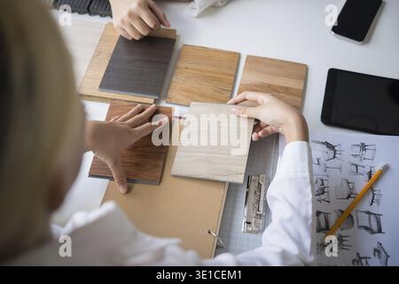 Innenarchitektin präsentiert umweltfreundliche Holzmaterialmuster für nachhaltige Wohnkultur Stockfoto